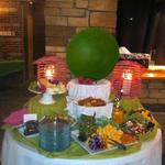 Appetizer table with red pepper tapenade, olives, dried fruits,apples, variety of cheeses served with crackers and garlic toast